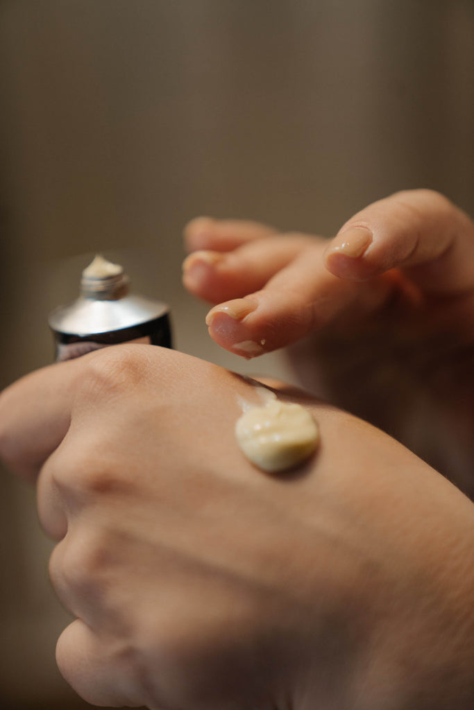 Woman applying hand lotion to the back of her hand