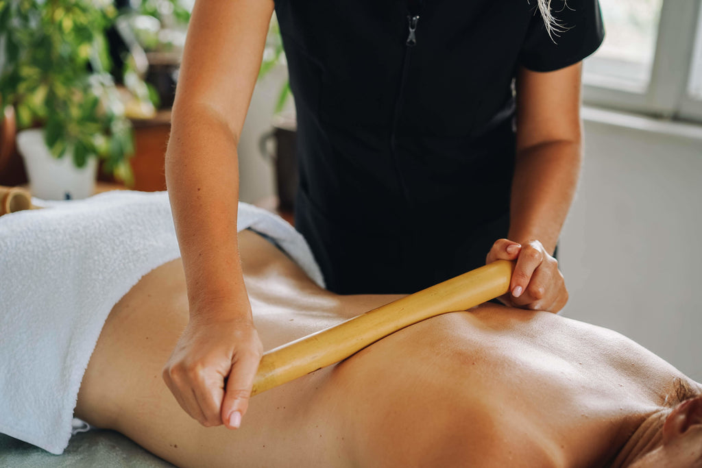 Woman getting a back massage with wooden roller